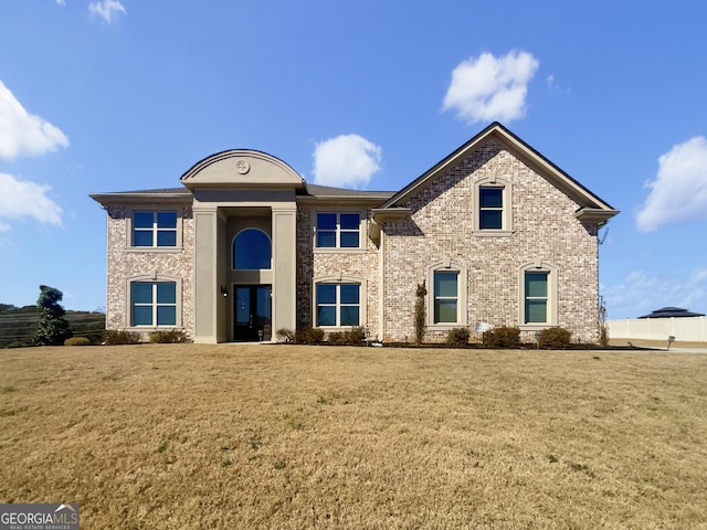 view of front of house featuring brick siding and a front lawn