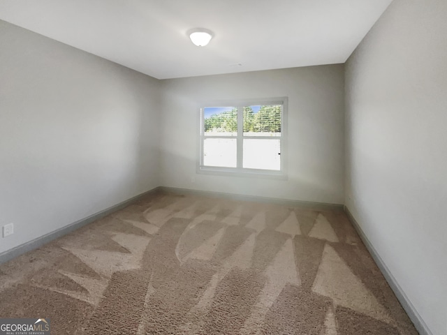 unfurnished room featuring baseboards and carpet