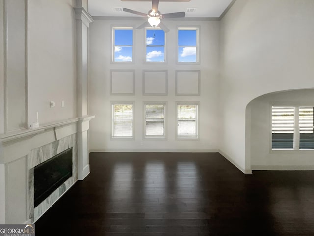 unfurnished living room featuring dark wood finished floors, a fireplace, visible vents, and baseboards