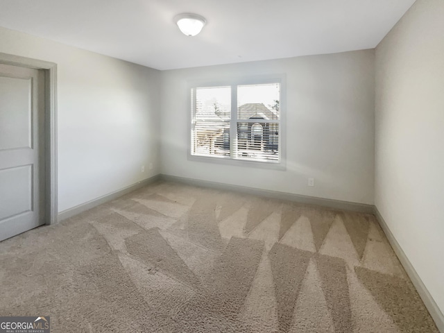 unfurnished room with baseboards and carpet