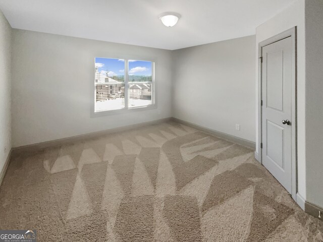 empty room with baseboards and carpet