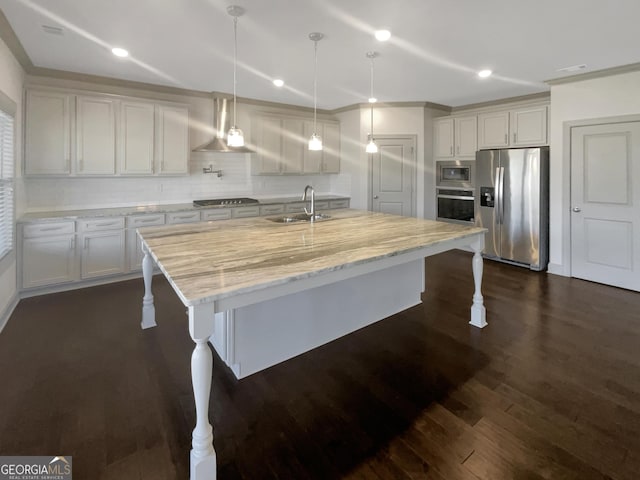 kitchen featuring dark wood-type flooring, a kitchen breakfast bar, appliances with stainless steel finishes, and a sink