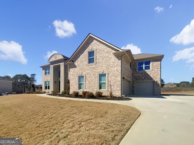 view of front facade featuring a front lawn, brick siding, a garage, and driveway