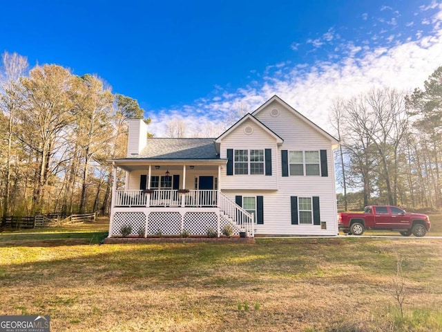 split level home with a porch, a front yard, and a chimney