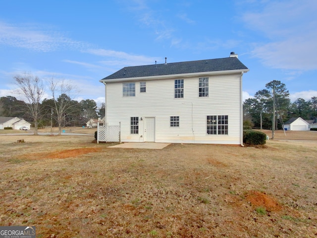 back of property featuring a lawn, a chimney, and a patio