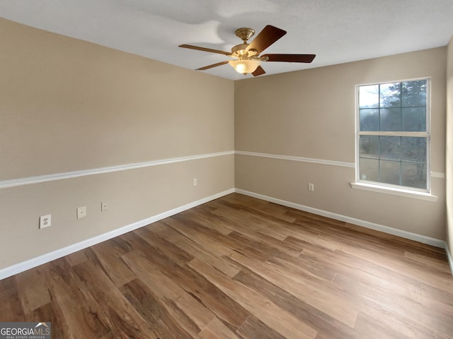 unfurnished room featuring ceiling fan, baseboards, and wood finished floors