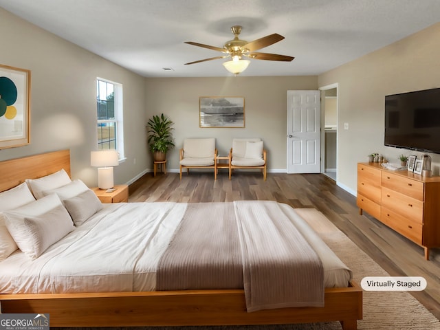 bedroom featuring baseboards, wood finished floors, and a ceiling fan