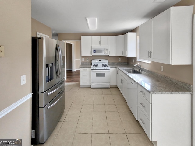 kitchen featuring a sink, white cabinetry, white appliances, light tile patterned floors, and light stone countertops