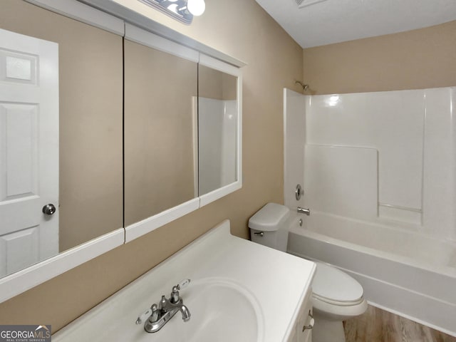 bathroom with shower / bath combination, toilet, wood finished floors, and vanity