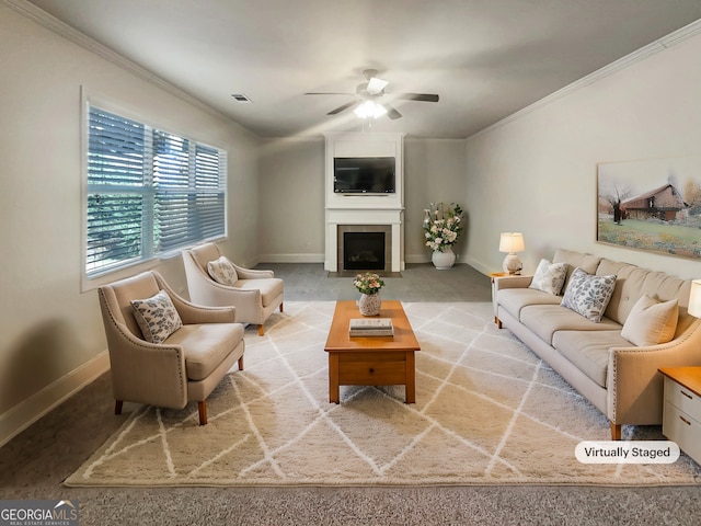 carpeted living room featuring baseboards, a large fireplace, ornamental molding, and a ceiling fan