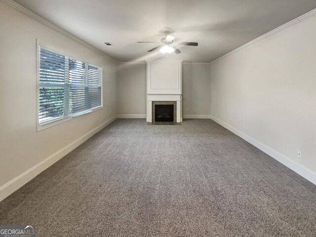 unfurnished living room featuring crown molding, a fireplace, baseboards, and light carpet