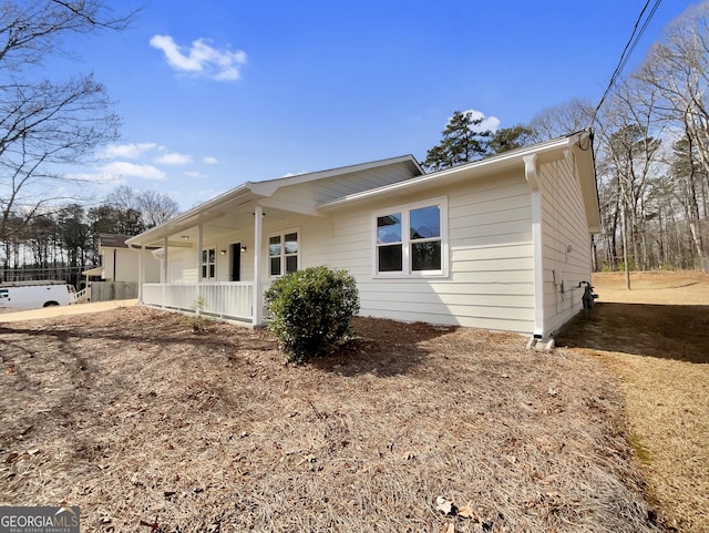 view of side of home featuring covered porch