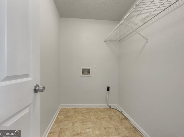 laundry room with baseboards, a textured ceiling, hookup for a washing machine, and laundry area