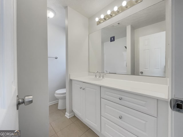 bathroom with tile patterned flooring, baseboards, toilet, vanity, and a textured ceiling