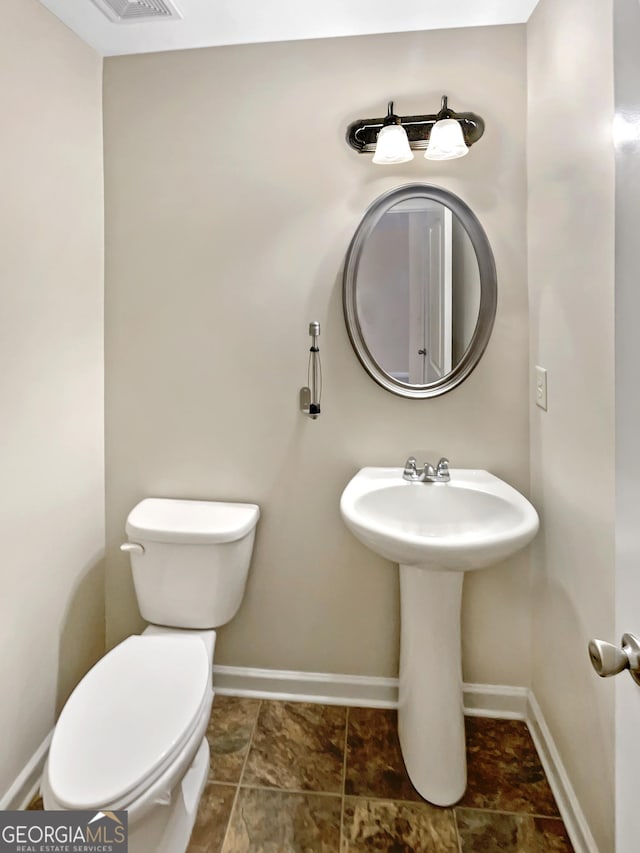 bathroom featuring toilet and baseboards