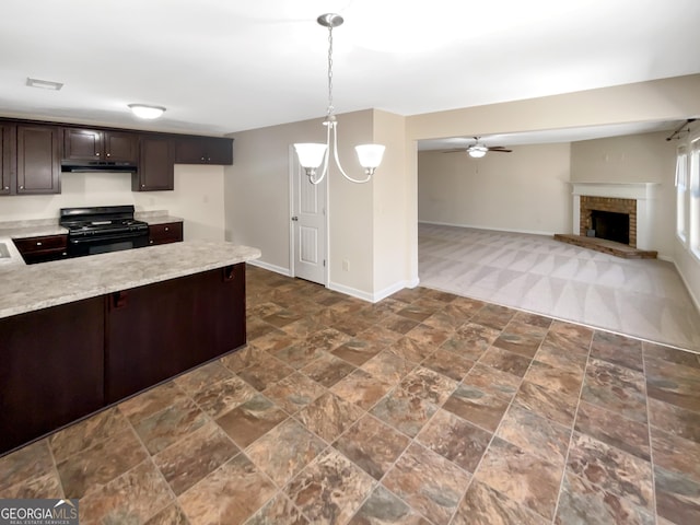 kitchen with black range with gas stovetop, dark brown cabinets, baseboards, ceiling fan with notable chandelier, and a fireplace