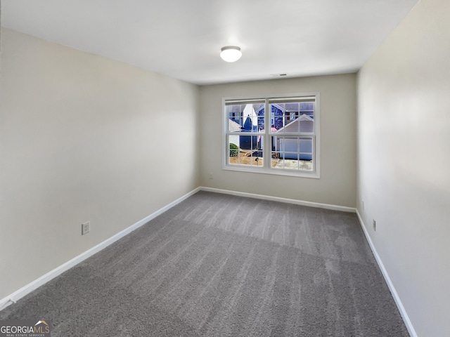 carpeted empty room with visible vents and baseboards