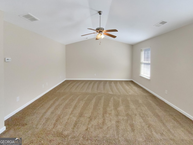 spare room featuring visible vents, baseboards, and lofted ceiling