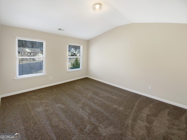 1181 Paramount Dr, Mcdonough, GA 30253 - unfurnished room with vaulted ceiling and dark colored carpet
