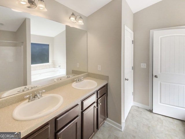 full bathroom featuring double vanity, a bath, and a sink