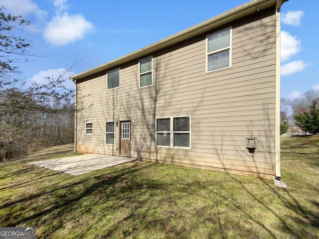 back of house featuring a patio and a yard