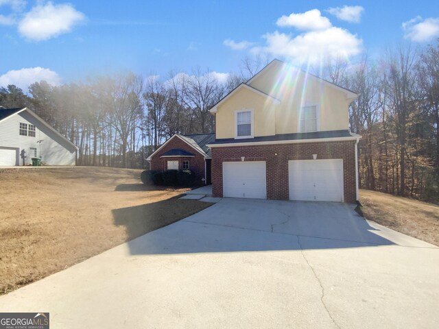 view of front of home with a garage, brick siding, and concrete driveway