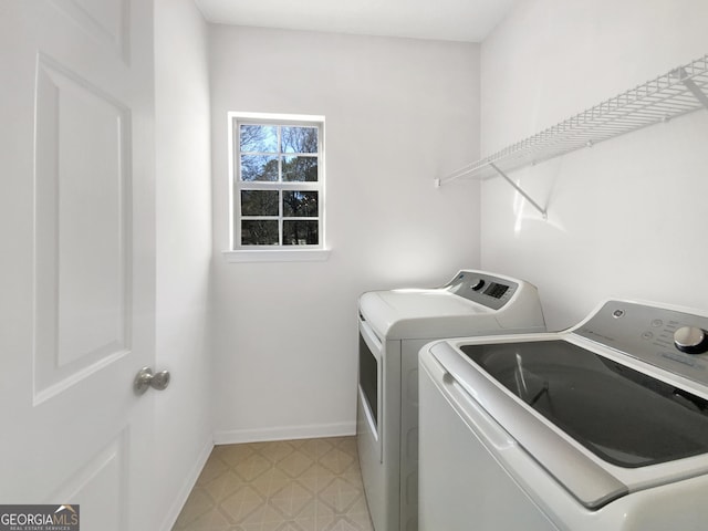 washroom featuring laundry area, separate washer and dryer, baseboards, and light floors