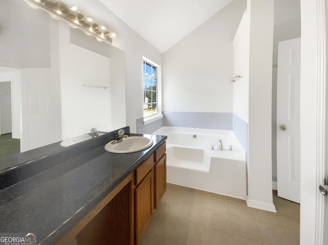 bathroom with tile patterned flooring, a garden tub, vanity, and lofted ceiling