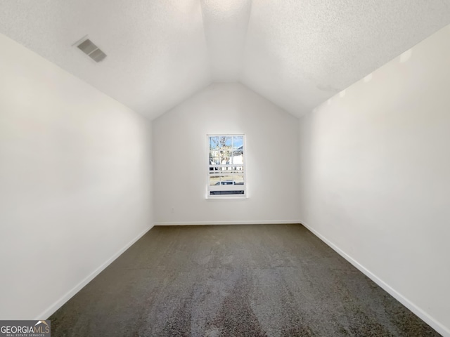 bonus room featuring visible vents, baseboards, lofted ceiling, a textured ceiling, and dark colored carpet