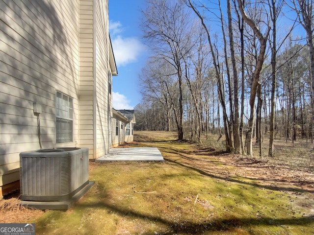 view of yard featuring central air condition unit and a patio area