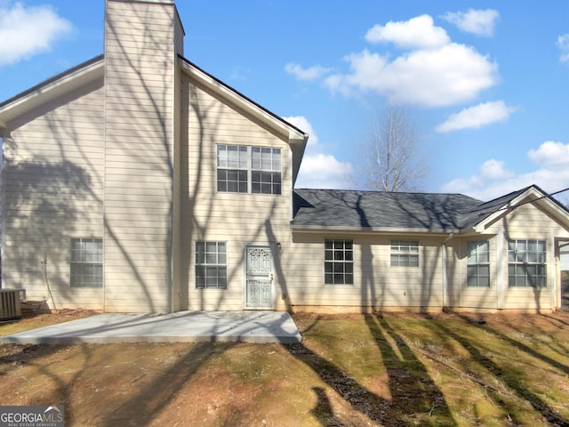 rear view of house featuring a chimney and a patio area