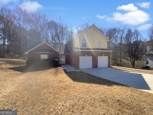 traditional-style house featuring a front lawn, an attached garage, brick siding, and driveway