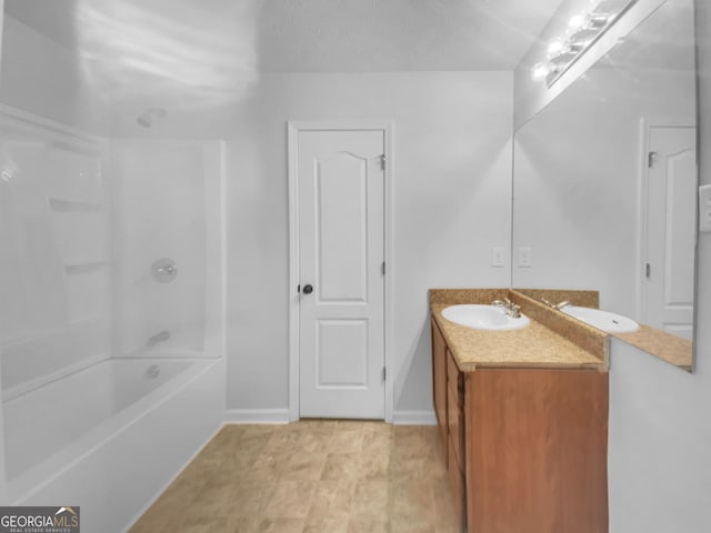 bathroom featuring vanity, shower / bath combination, and baseboards