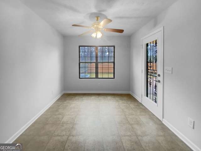 spare room featuring baseboards and ceiling fan