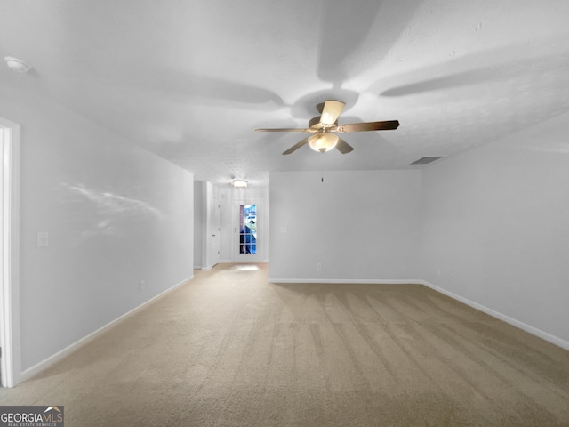 empty room featuring light carpet, visible vents, baseboards, and a ceiling fan