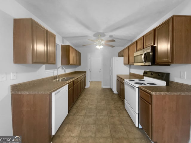 kitchen with brown cabinets, a sink, dark countertops, white appliances, and ceiling fan