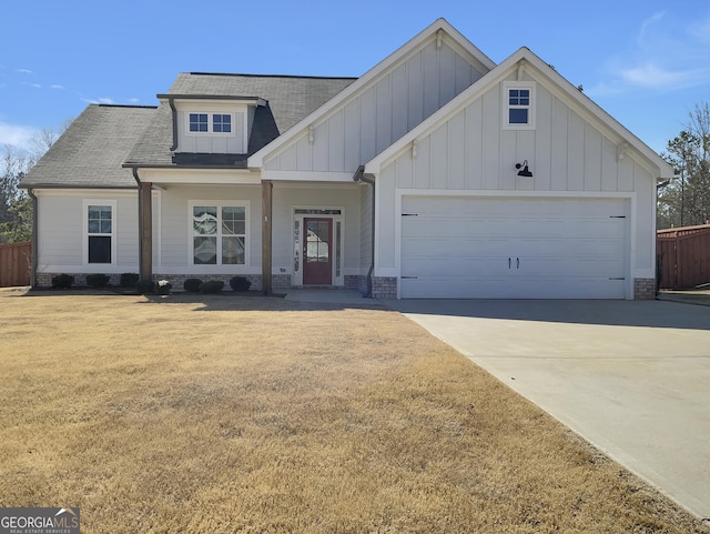 view of front facade with fence, an attached garage, a shingled roof, concrete driveway, and board and batten siding