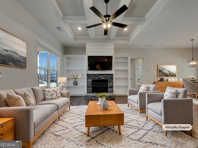 living room with beamed ceiling, visible vents, coffered ceiling, wood finished floors, and a stone fireplace