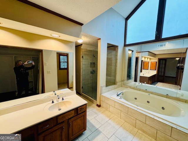 bathroom featuring visible vents, a shower stall, a jetted tub, vanity, and a textured ceiling