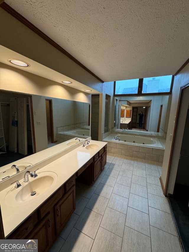 bathroom featuring a sink, a jetted tub, and double vanity