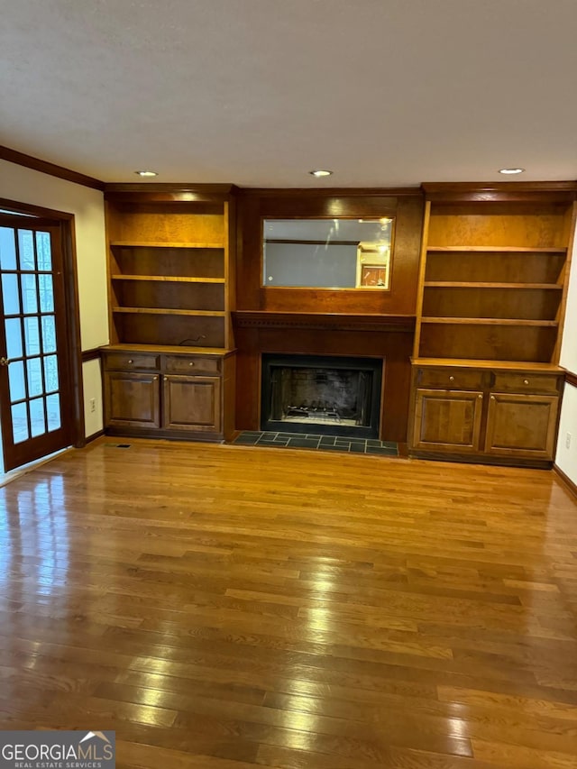 unfurnished living room featuring ornamental molding, wood finished floors, recessed lighting, a fireplace, and baseboards