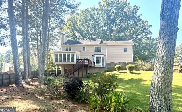 rear view of property featuring a lawn, a fenced backyard, stairs, a sunroom, and a chimney