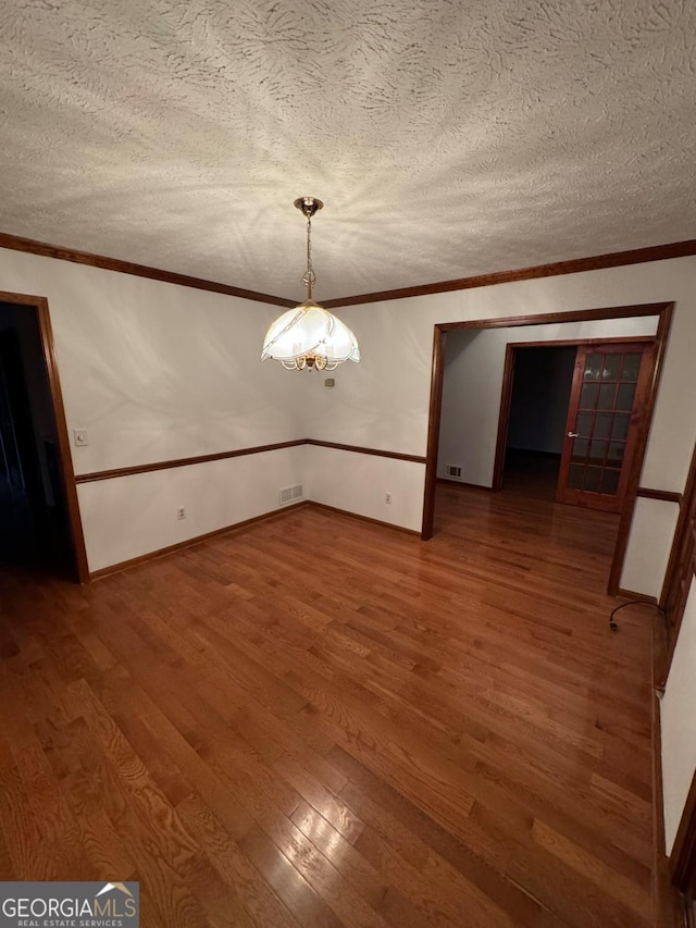 unfurnished dining area featuring crown molding, wood finished floors, and visible vents