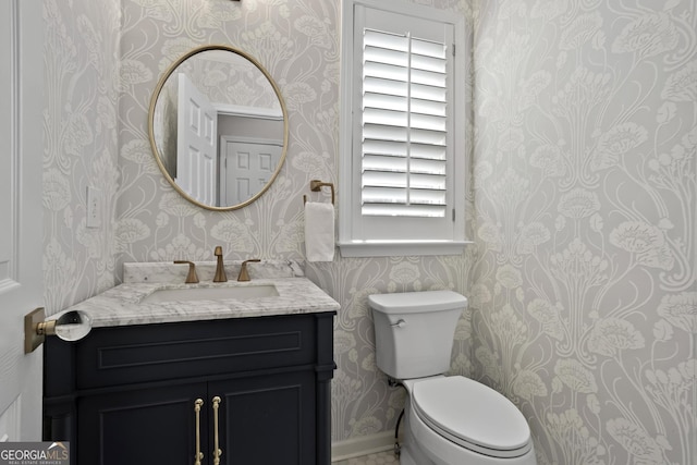 bathroom with wallpapered walls, toilet, and vanity