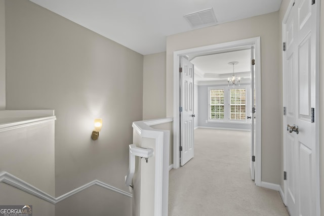 interior space featuring a raised ceiling, a notable chandelier, baseboards, and visible vents