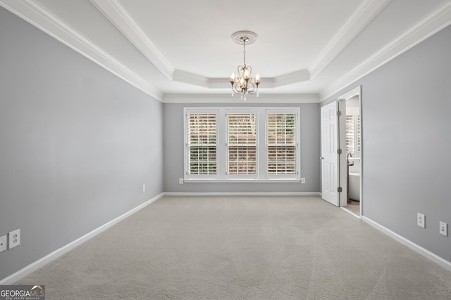 carpeted empty room featuring crown molding, baseboards, a raised ceiling, and an inviting chandelier