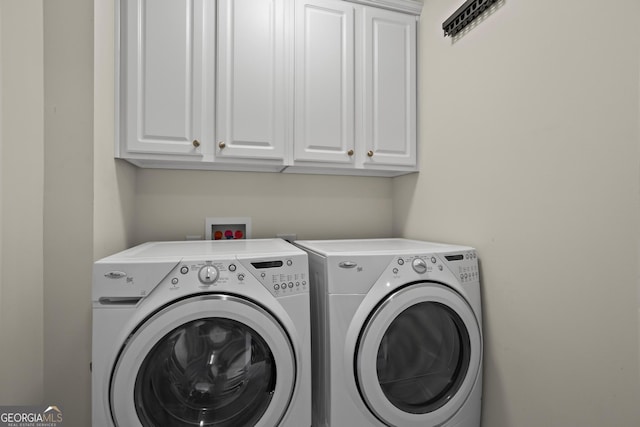 clothes washing area featuring cabinet space and independent washer and dryer