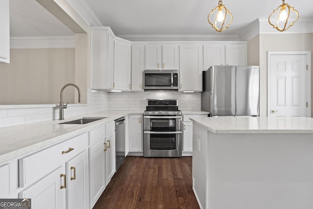 kitchen with tasteful backsplash, ornamental molding, appliances with stainless steel finishes, white cabinetry, and a sink