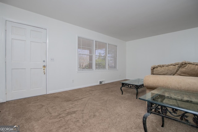 living area with visible vents, baseboards, and carpet