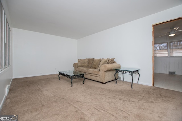 living room featuring visible vents, carpet floors, baseboards, and ceiling fan